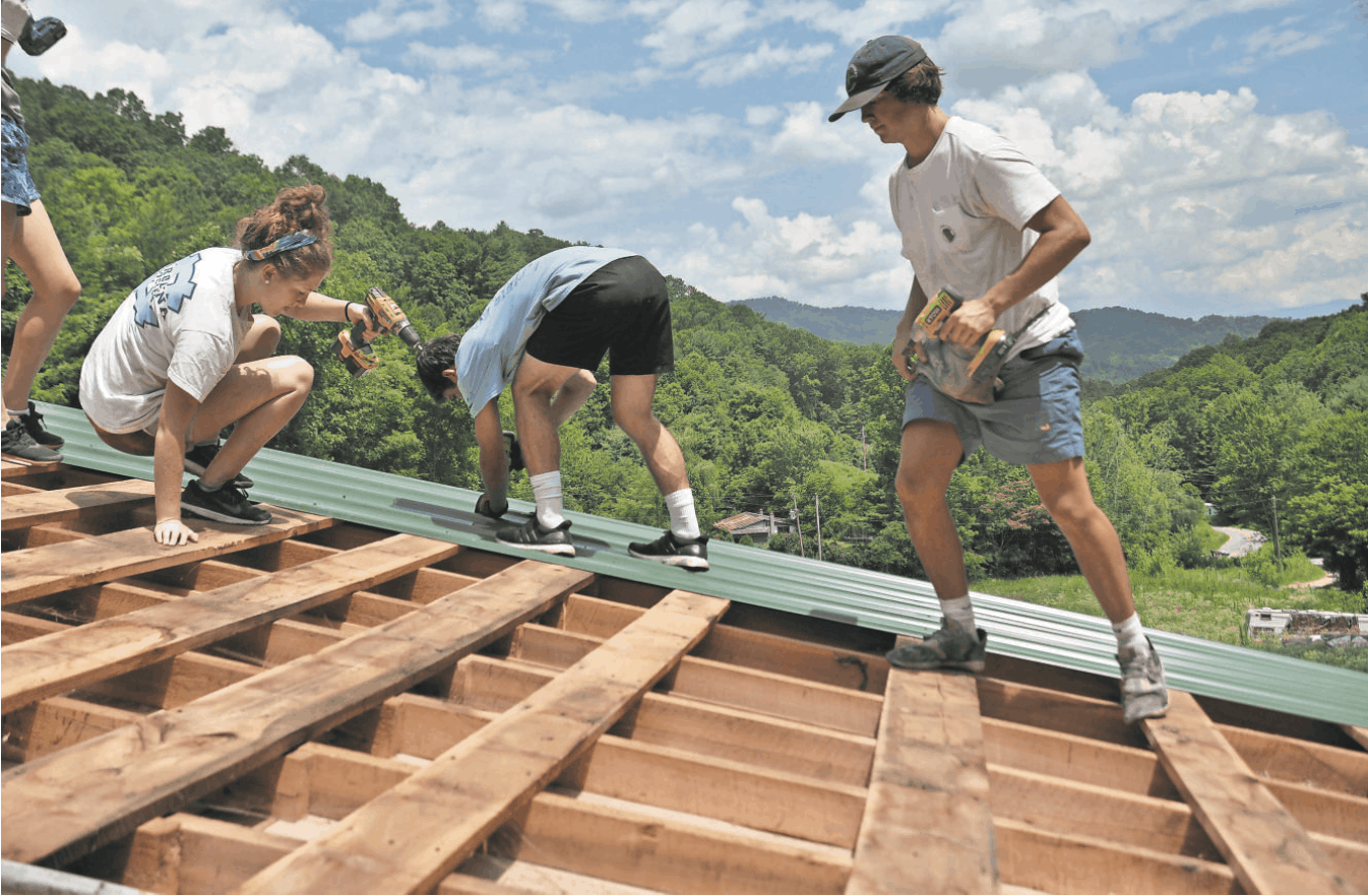 Group of CHC volunteers repairing a roof.